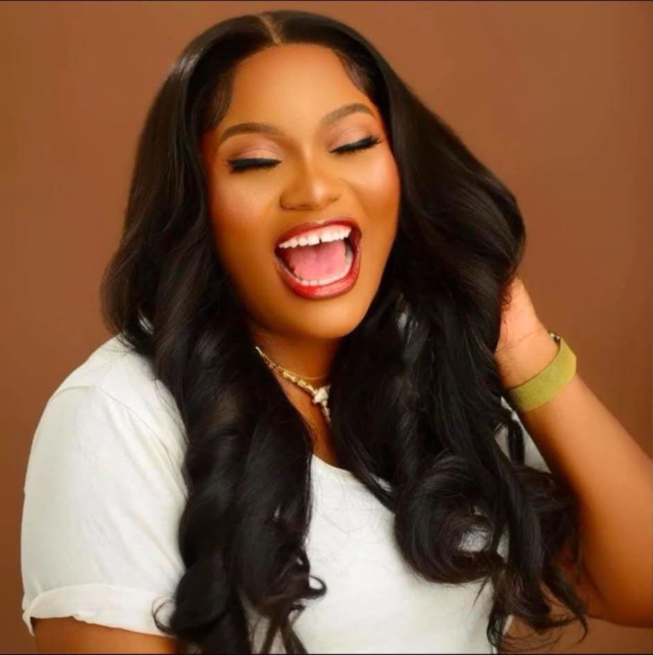 Cagzin Experience client laughing, wearing natural wave wig
